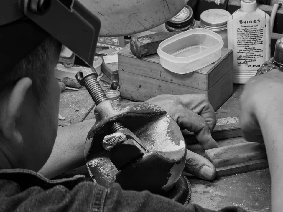 Close-up of a jeweler shaping metal in the Bangkok workshop